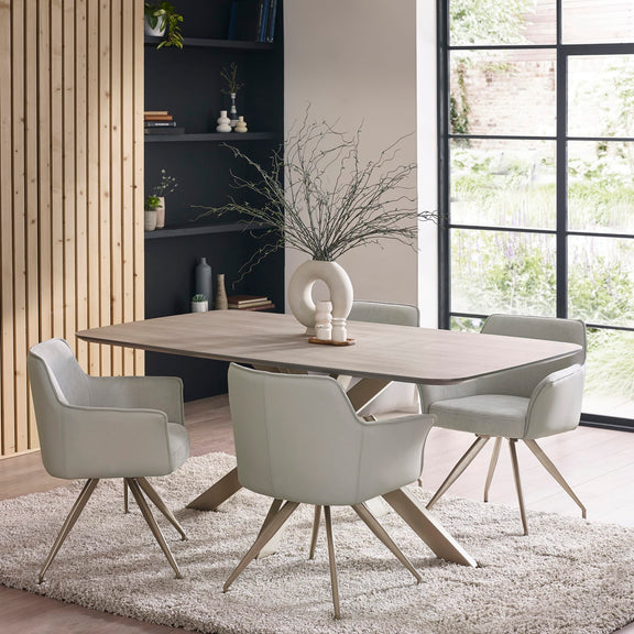 Dining room with a wooden table and four chairs in a modern interior setting.