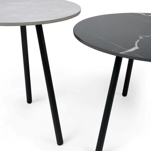 Two round tables with marble-like tops and black legs on a white background