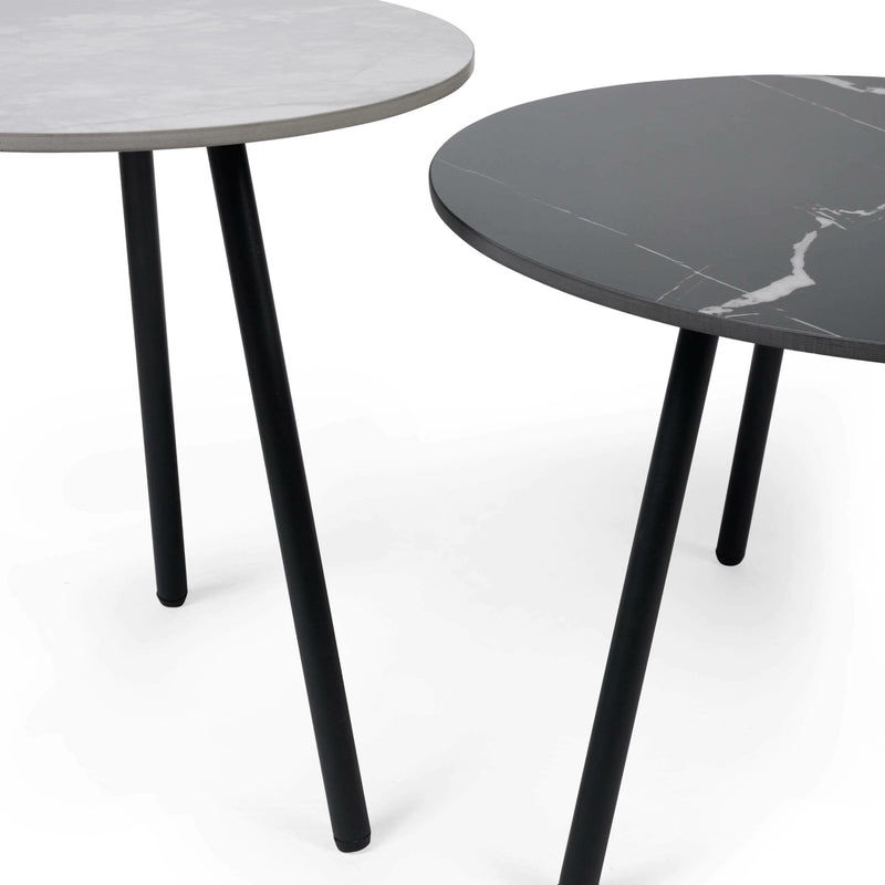 Two round tables with marble-like tops and black legs on a white background
