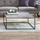 Coffee table with a gray marble top and black metal frame in a living room setting.