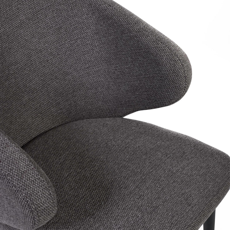 Close-up of a gray upholstered chair with a textured fabric finish.