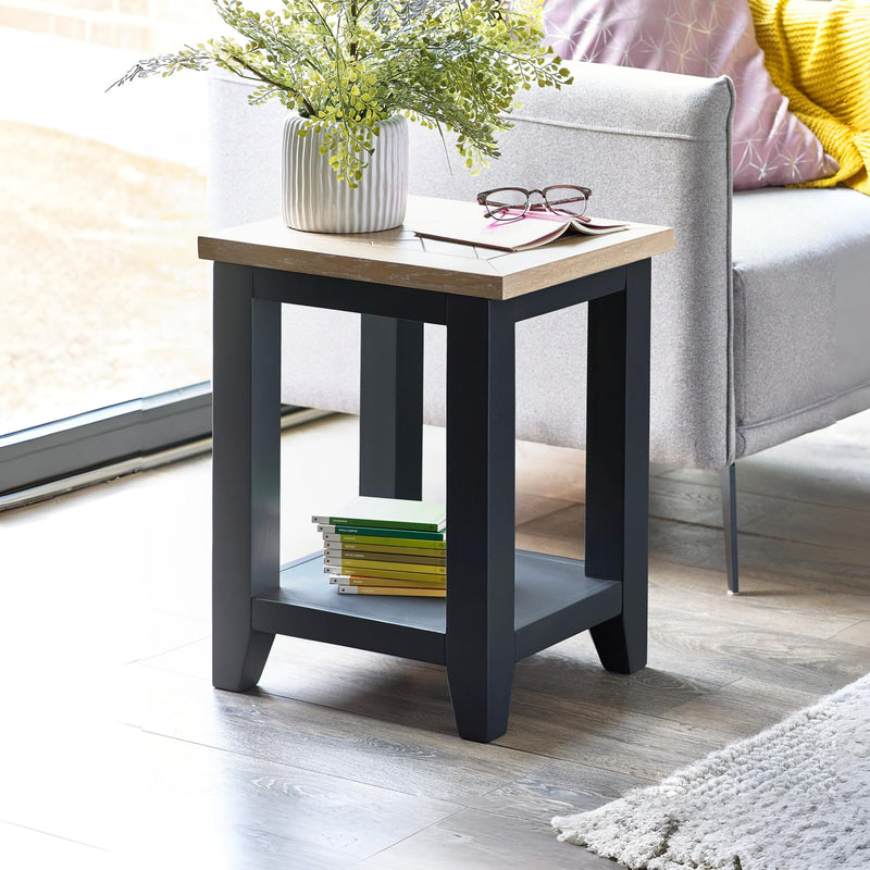 Small side table with a plant, books, and glasses in a living room setting.