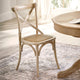 Wooden chair with woven seat next to a round wooden table in a bright room.