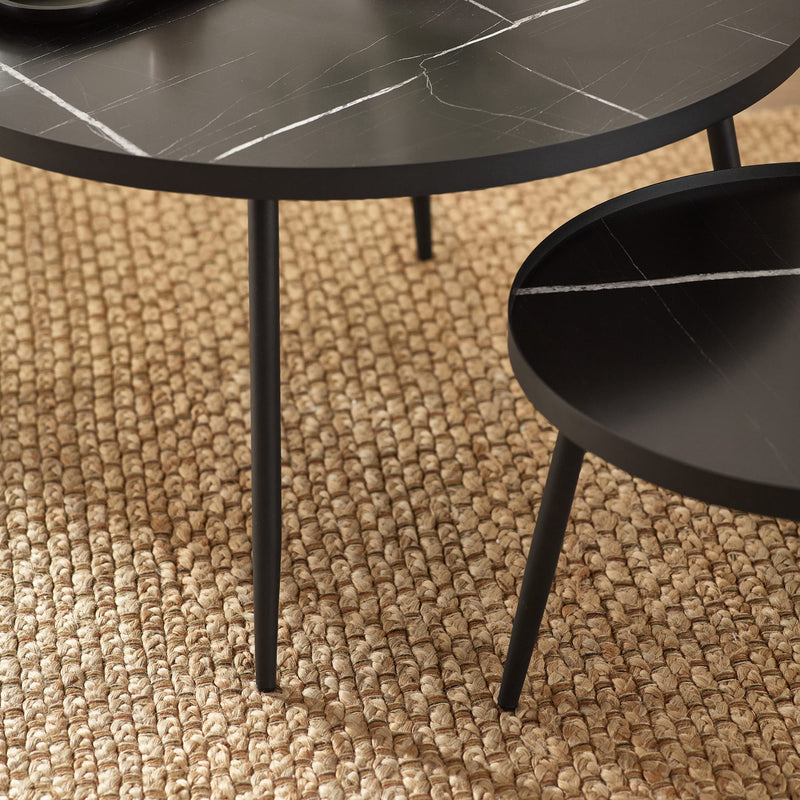 Two round black marble tables on a textured brown carpet