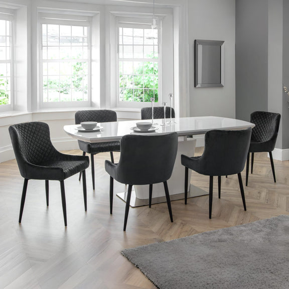 Dining room with a round table and six chairs in a well-lit room.