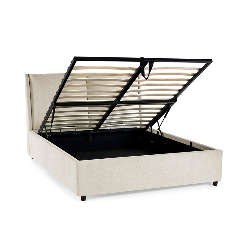 Beige upholstered bed with black metal frame on a white background
