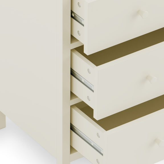 Stack of white drawers with gold accents on a light beige background