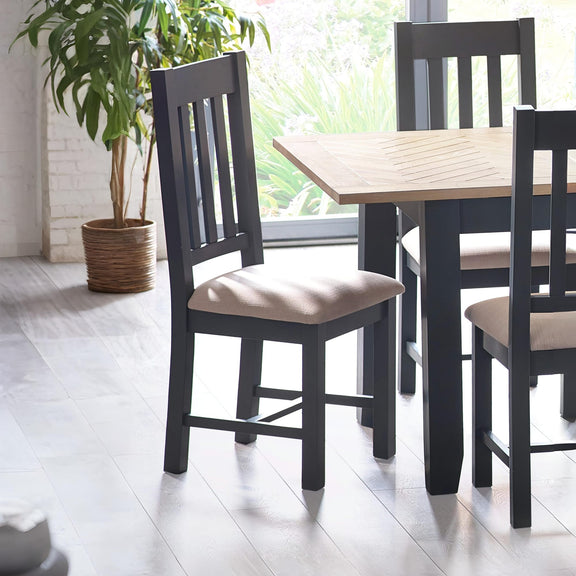 Dining table with chairs in a bright room with a plant.