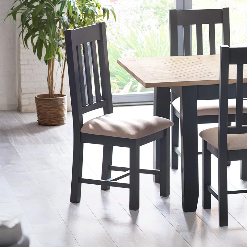 Dining table with chairs in a bright room with a plant.