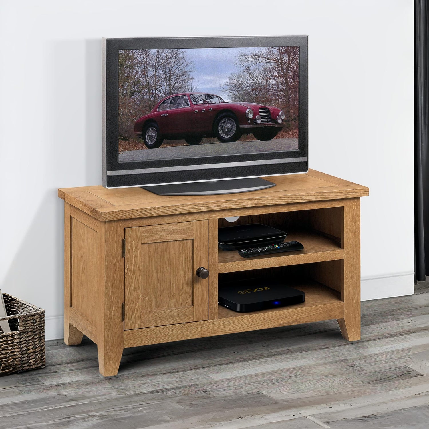 Wooden TV stand with a television displaying an image of a red car on a white wall.