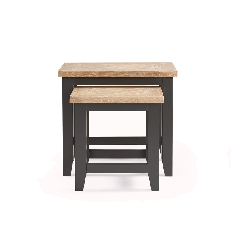 Set of two nesting tables with wooden tops and black bases on a white background