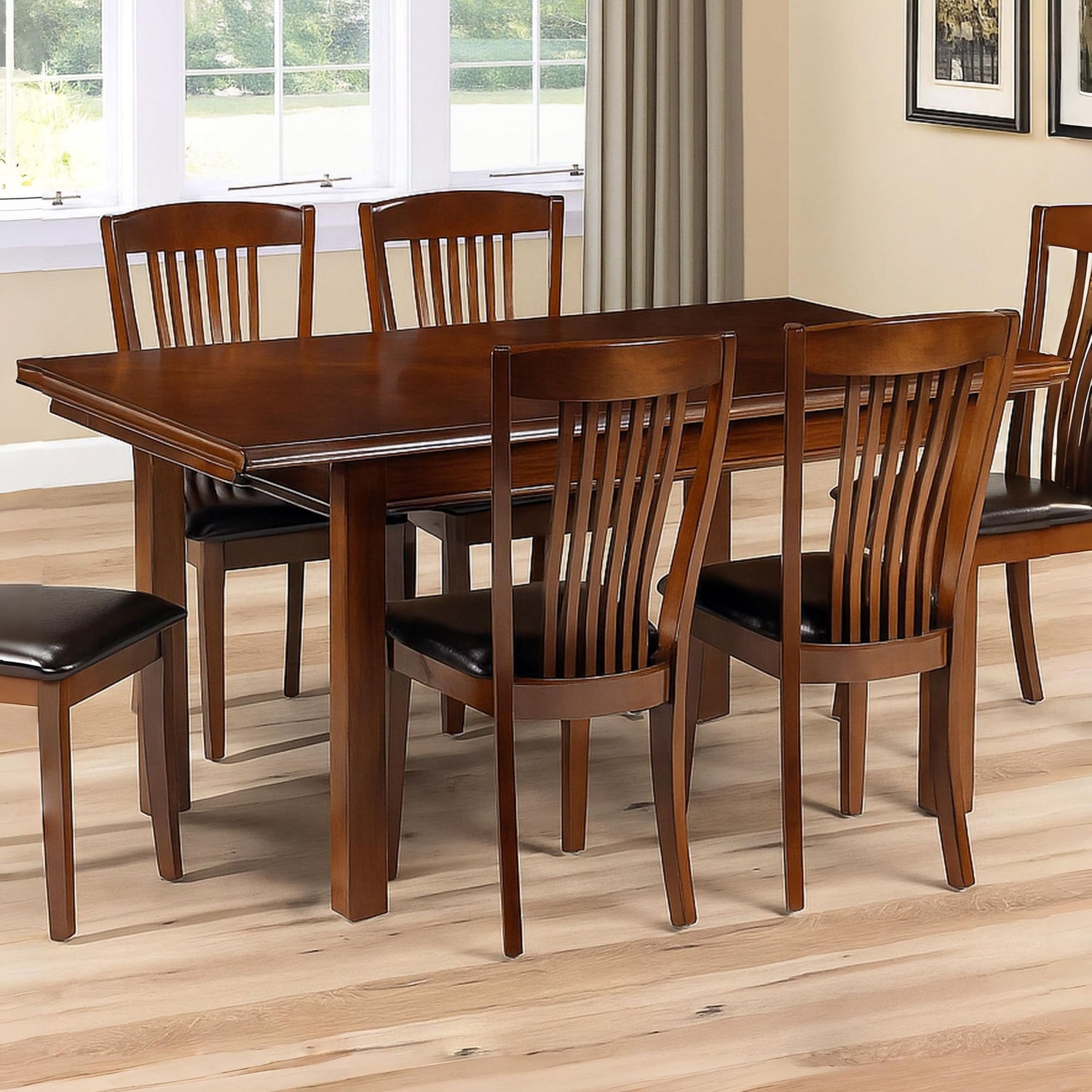 Wooden dining table with chairs in a room with large windows.