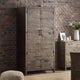 Wooden wardrobe against a brick wall with a side table and decor items.