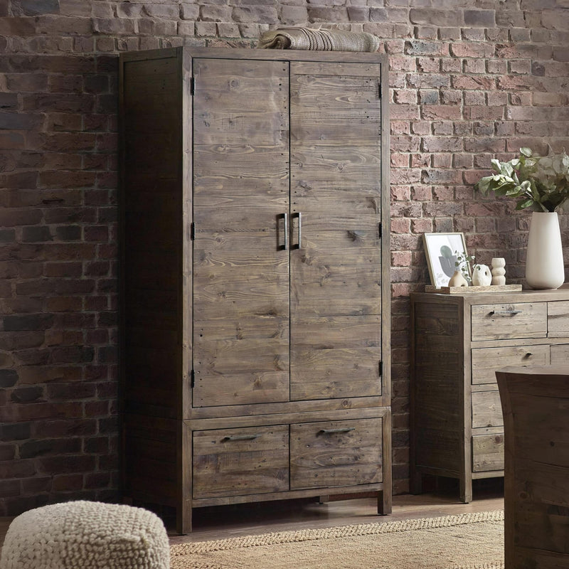 Wooden wardrobe against a brick wall with a side table and decor items.