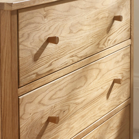 Wooden dresser with four drawers and brass handles.