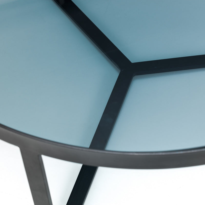 Close-up of a modern chair with glass seat and metal frame on a white background