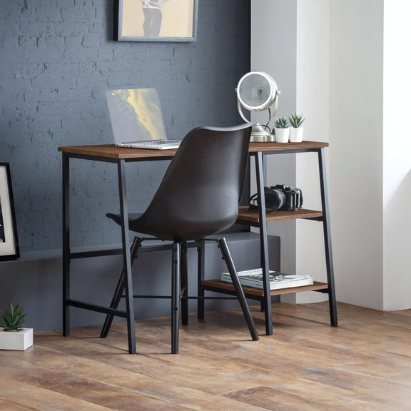 Modern home office with a wooden desk, black chair, and decor items.