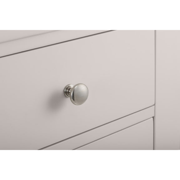 Close-up of a light gray cabinet with a silver knob on a white background