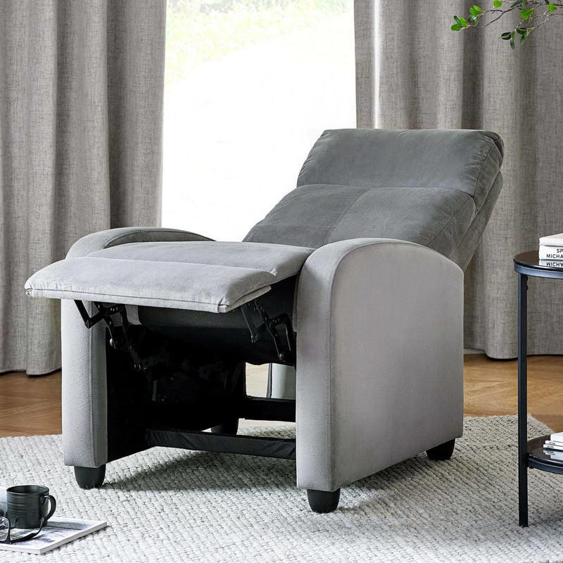 Gray recliner chair in a living room setting with curtains and a table.