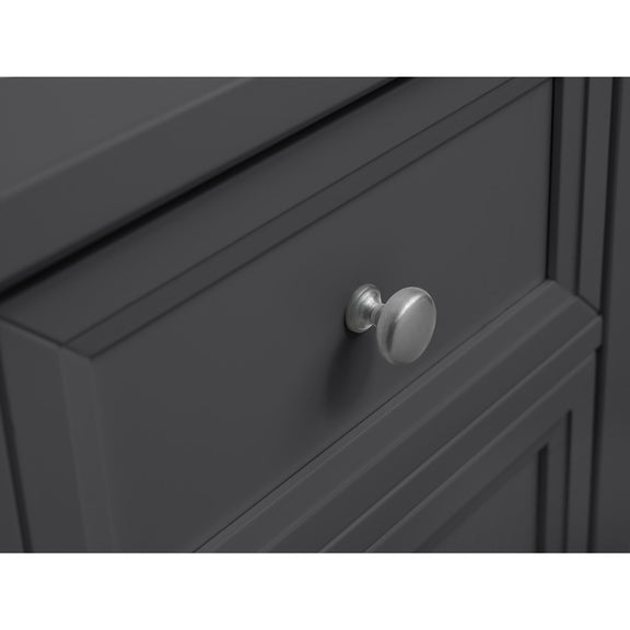 Close-up of a dark gray cabinet with a silver knob on a white background