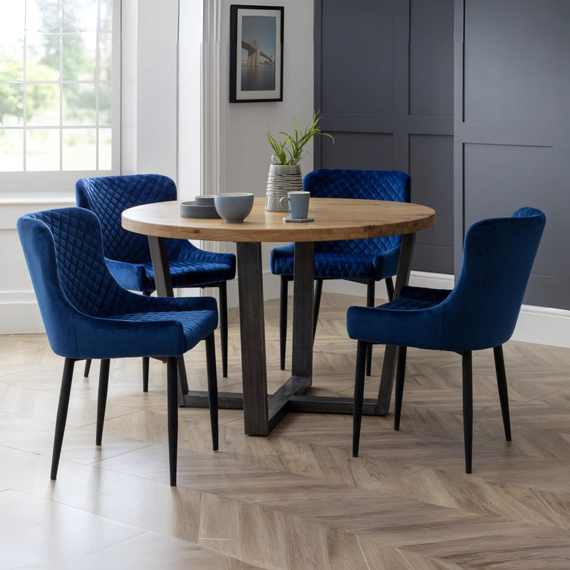 Dining room with a wooden table and blue chairs in a well-lit room.