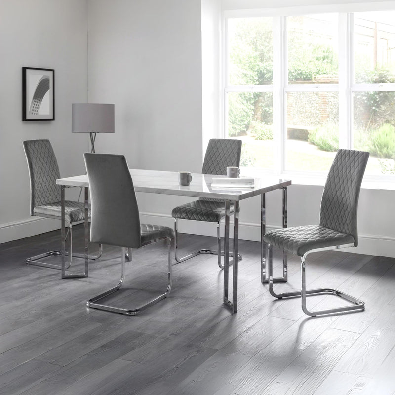 Modern dining room with a glass table and four chairs in a well-lit room.