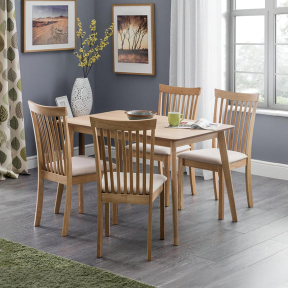 Dining room with wooden table and chairs against a gray wall.
