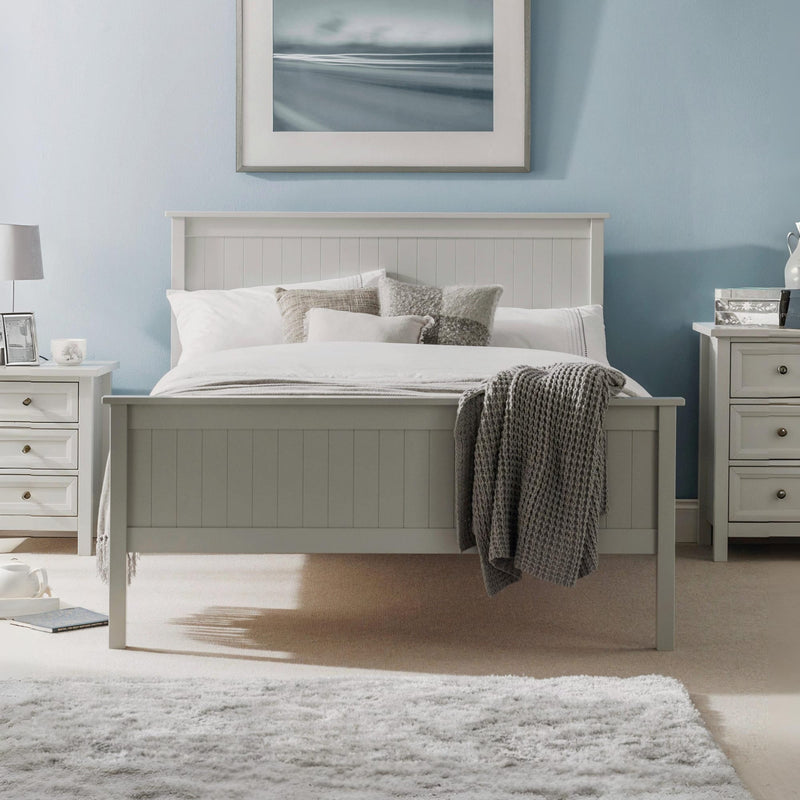 Gray wooden bed in a bedroom with light blue walls, framed picture, and nightstands.