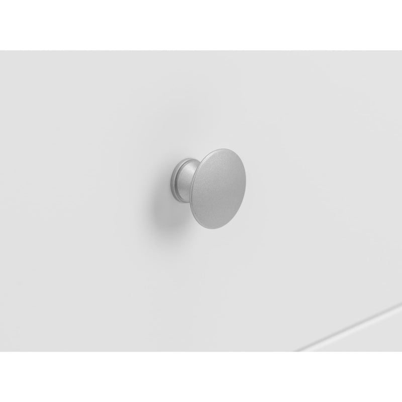Metallic cabinet knob on a white drawer