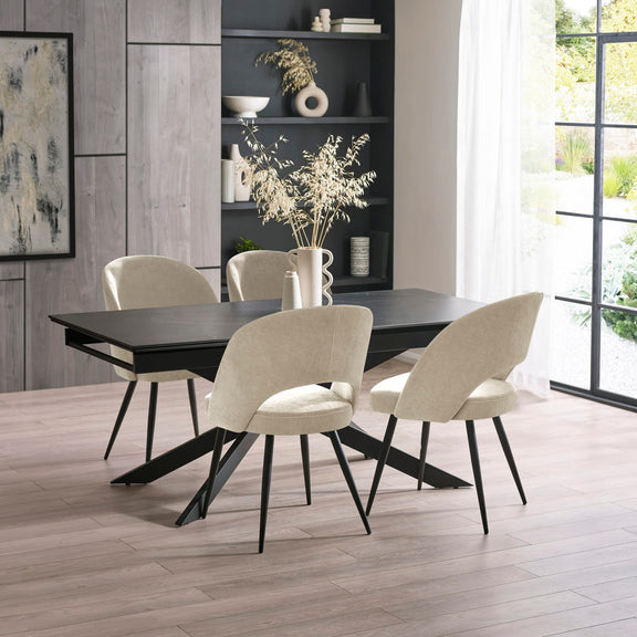Dining room with a black table and beige chairs in a modern interior setting.