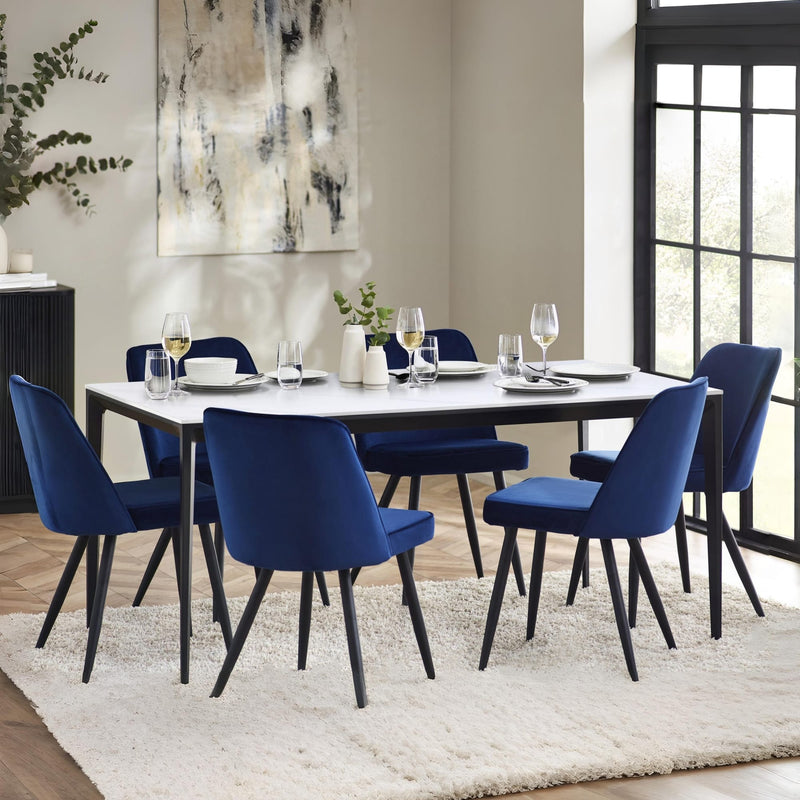 Dining room with a table and blue chairs in a well-lit room.
