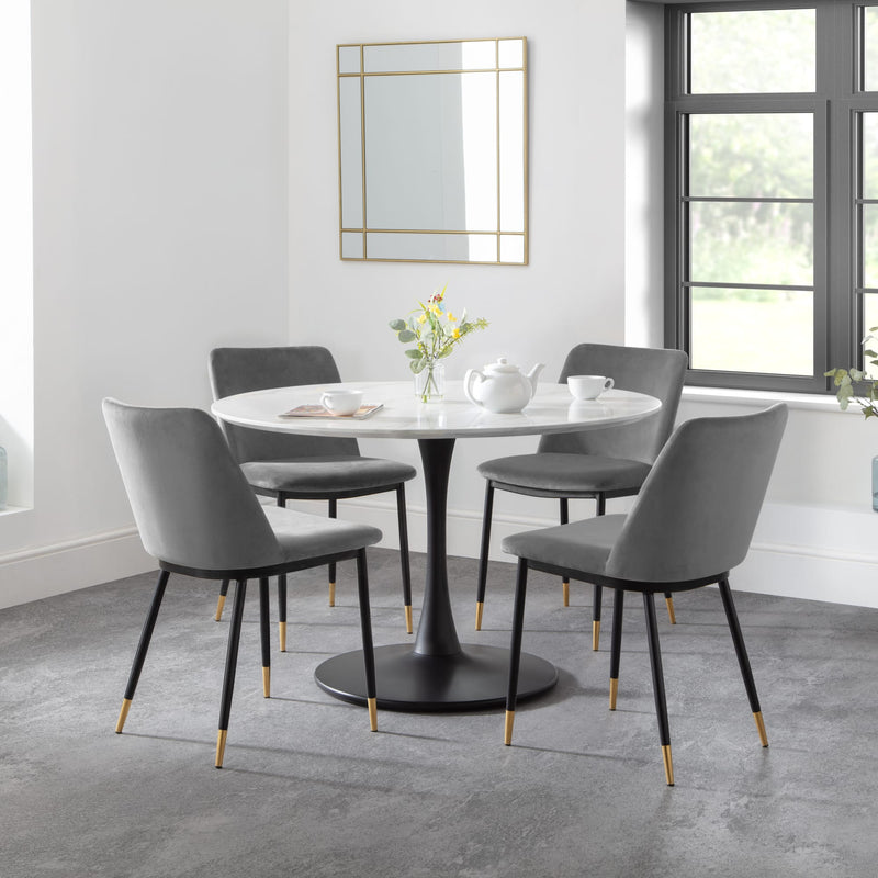 Dining room with a round table and gray chairs in a modern interior.