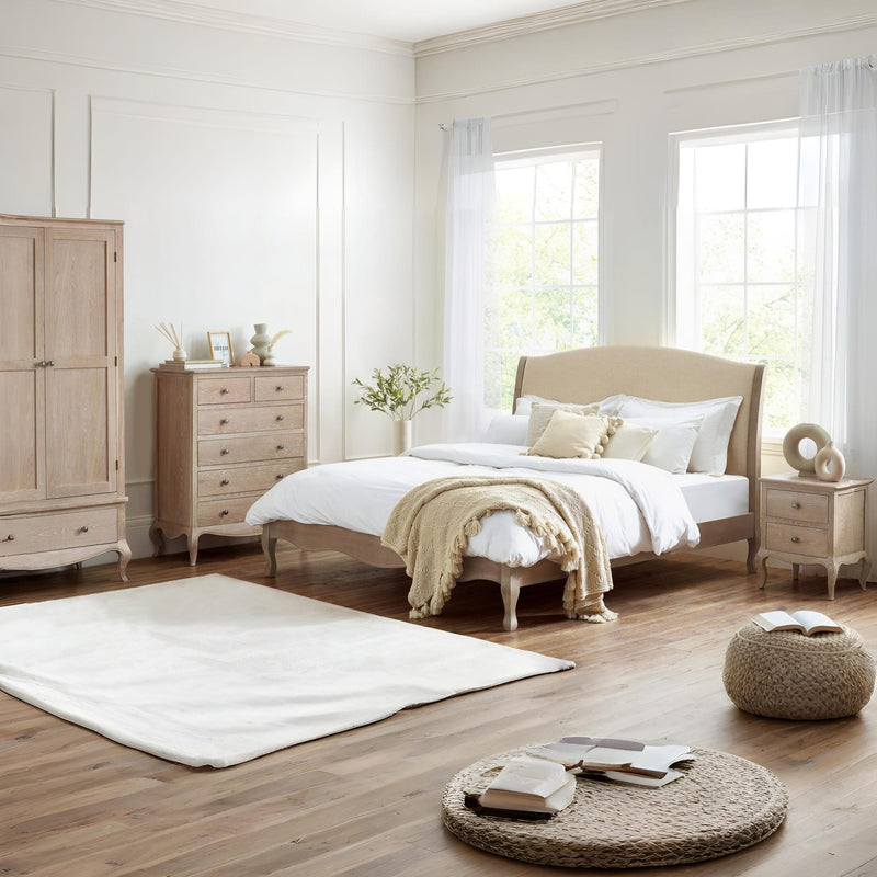 Neatly arranged bedroom with wooden furniture and white bedding.