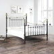 Black metal bed with gold accents in a bedroom setting