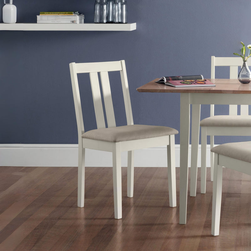 Dining room with wooden table and white chairs against a blue wall.