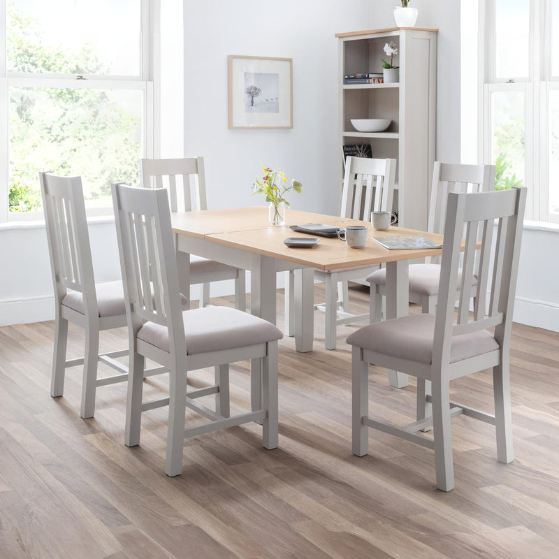 Dining room with a wooden table and gray chairs in a well-lit room.