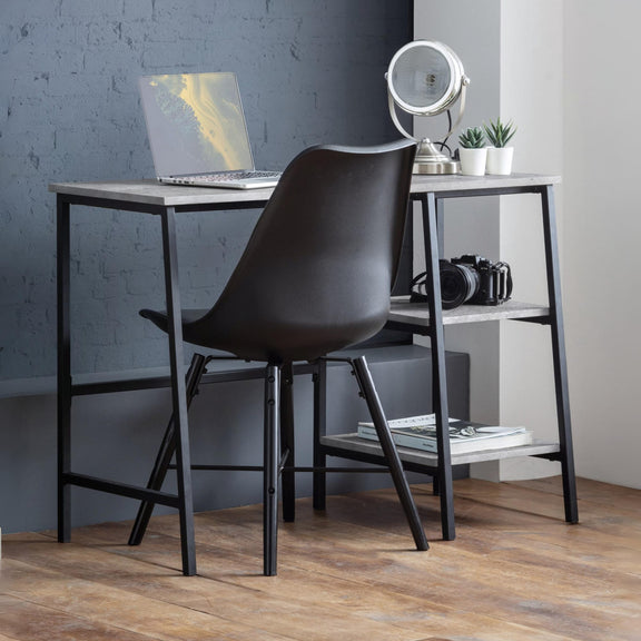 Modern desk with black chair against a gray wall