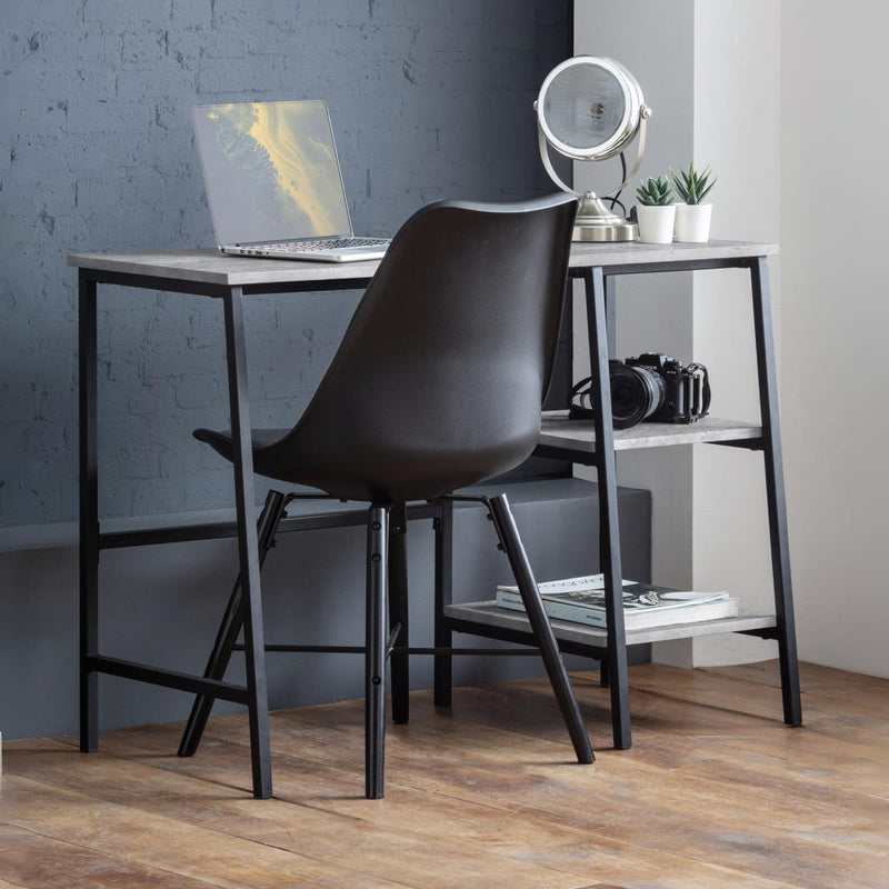 Modern desk with black chair against a gray wall