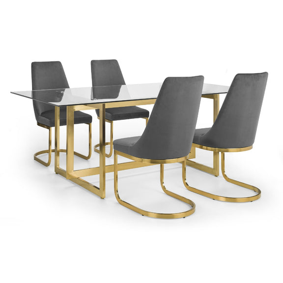 Dining table with glass top and gold legs accompanied by four gray chairs on a white background
