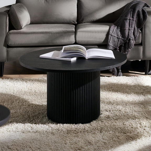 Black coffee table with an open book in a living room setting