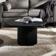 Black coffee table with an open book in a living room setting