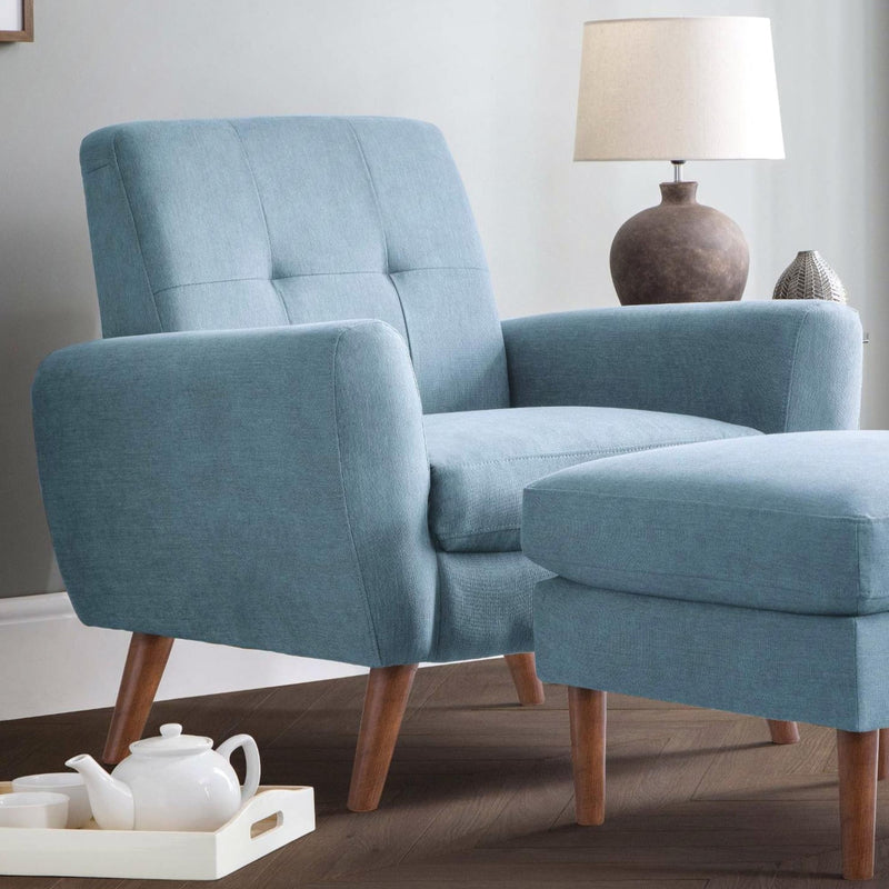 Blue armchair with wooden legs in a room setting with a lamp and tray.