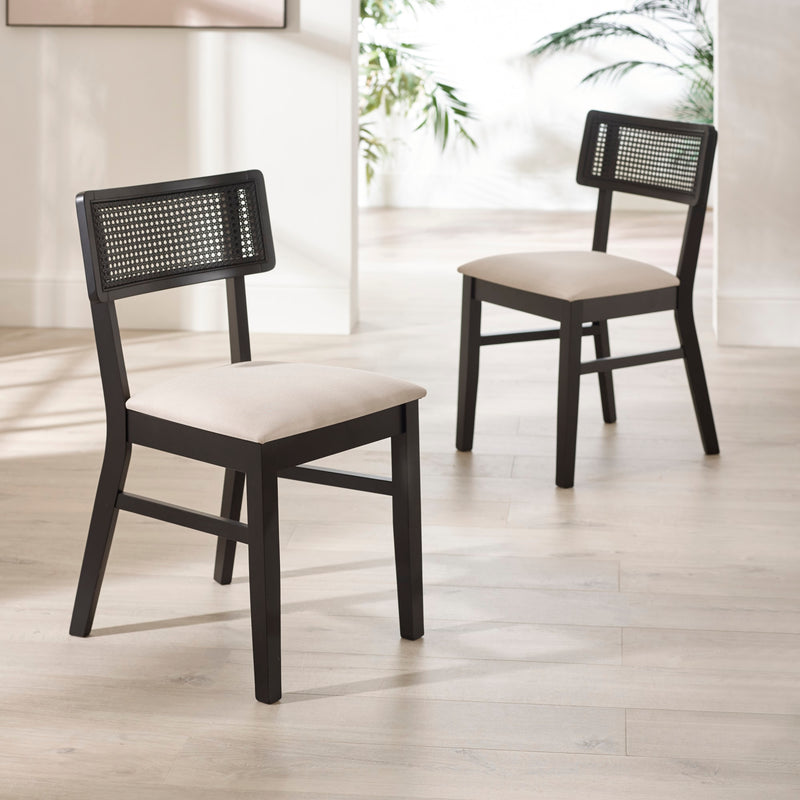 Two black chairs with woven backrests and beige cushions on a light wooden floor.