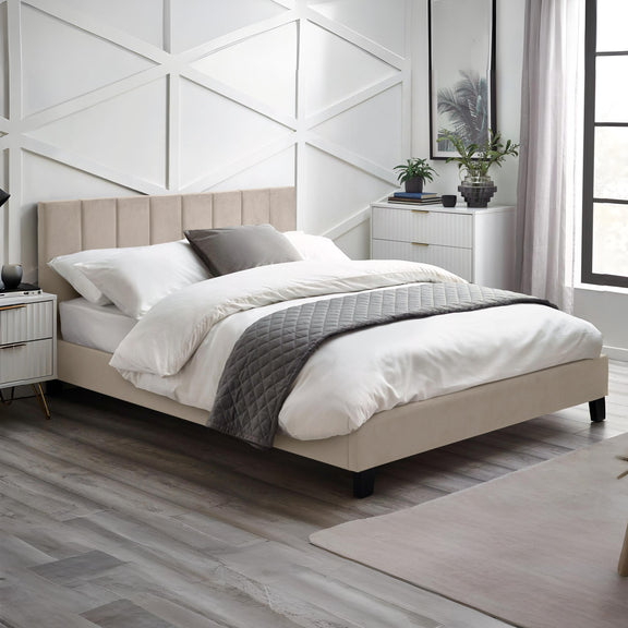 Neatly made bed in a modern bedroom with white walls and wooden flooring.