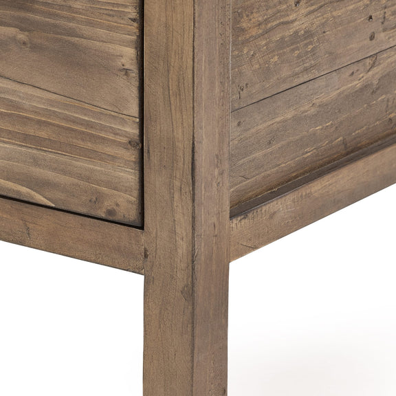 Close-up of a wooden cabinet corner with a rustic finish.