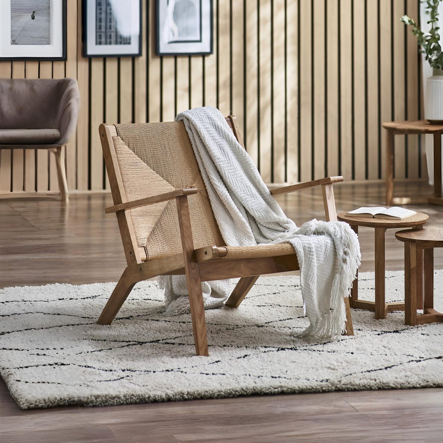 Wooden armchair with a blanket in a living room setting