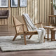 Wooden armchair with a blanket in a living room setting