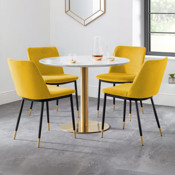 Round dining table with four yellow chairs in a modern interior setting.