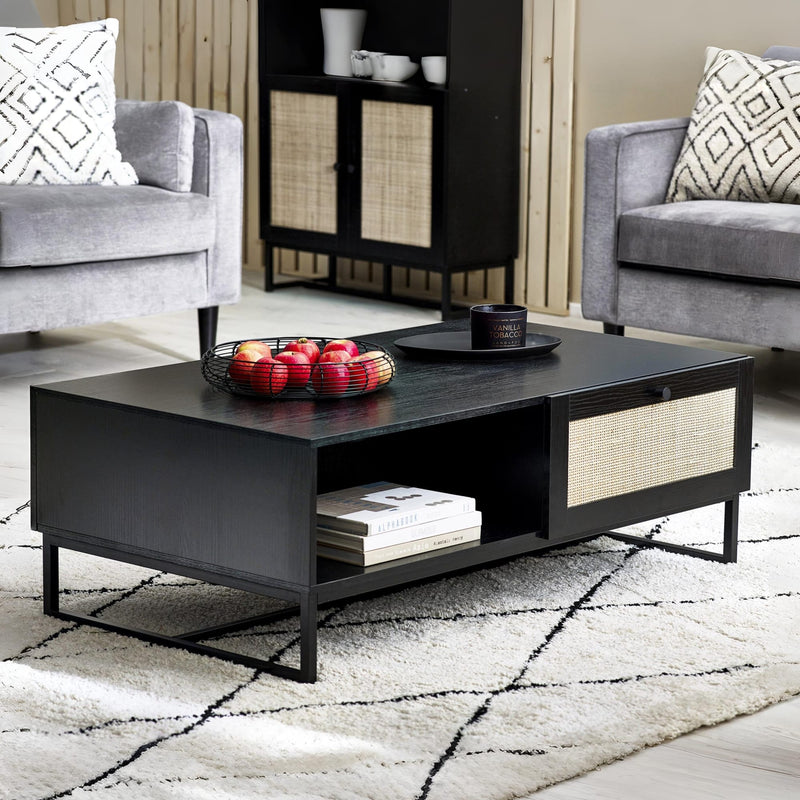 Black coffee table with decorative items in a living room setting