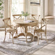 Round wooden dining table with four matching chairs in a bright room.